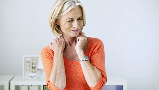 Mature woman suffering from neck and shoulder pain before visiting Buckeye chiropractor