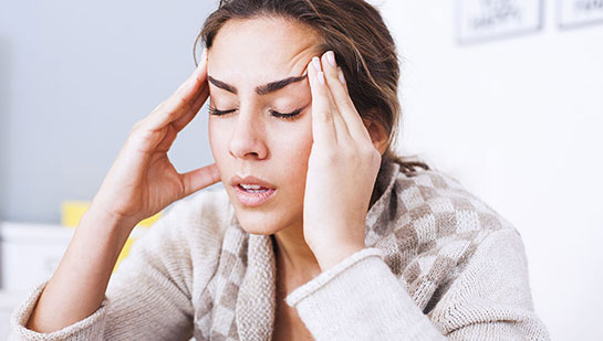 Woman suffering from headache before visiting Buckeye chiropractor